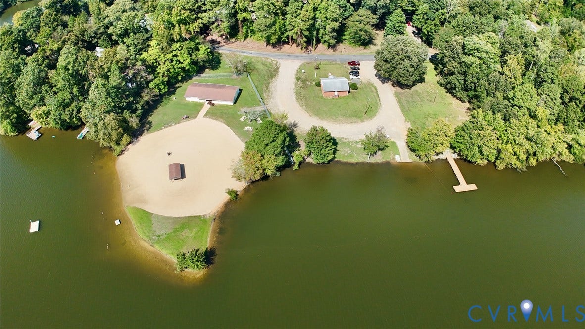 6723 Cherry Road, Woodhaven Shores, Quinton, VA 23141 Drone - Community Common AreaWaterfront property featuring a private sandy beach, multiple buildings, a wooden dock, and extensive tree coverage