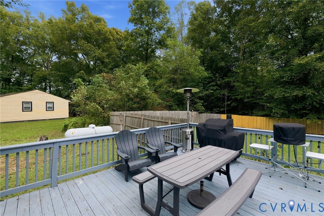 6723 Cherry Road, Woodhaven Shores, Quinton, VA 23141 Expansive wood-finish deck with a painted railing overlooking a spacious grass lawn and a separate yellow-sided outbuilding