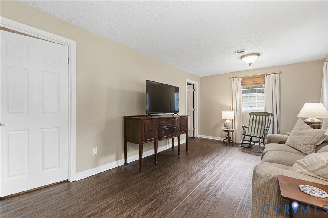 6723 Cherry Road, Woodhaven Shores, Quinton, VA 23141 Wood-finish flooring, neutral wall tones, window with natural light, white trim, and a ceiling-mounted light fixture