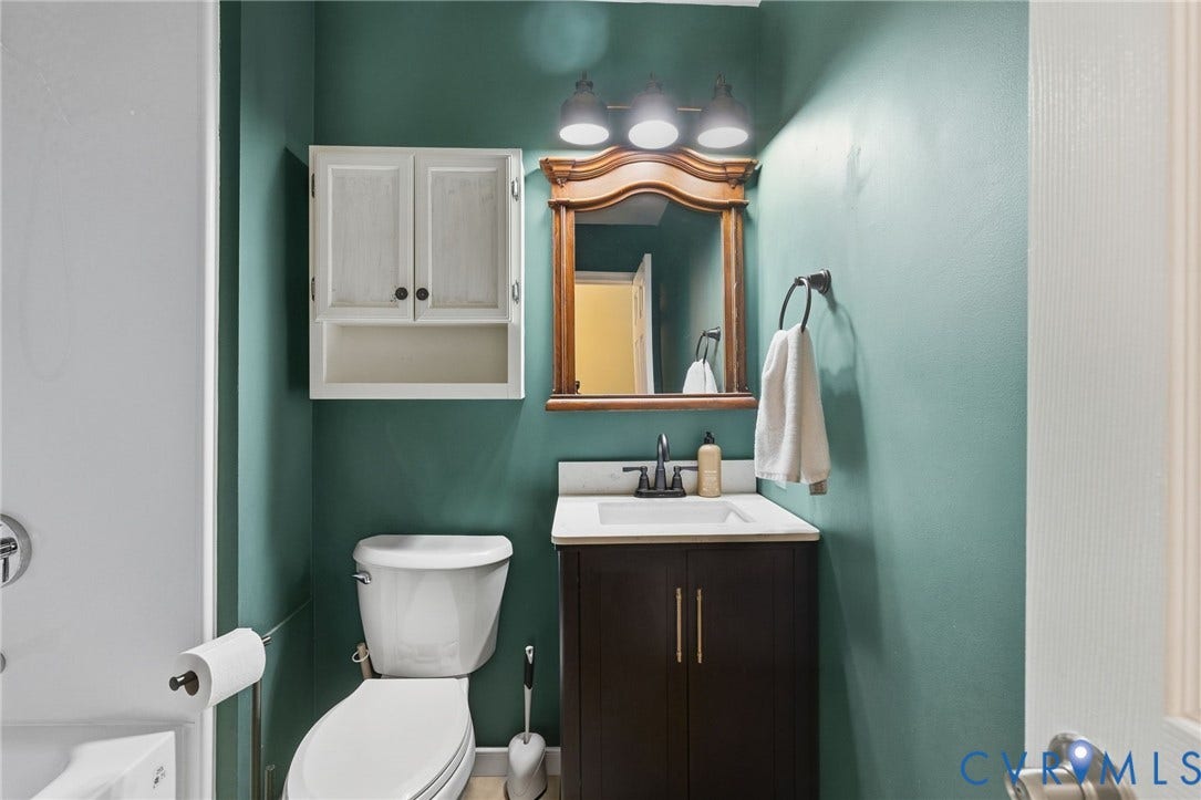 6723 Cherry Road, Woodhaven Shores, Quinton, VA 23141 Built-in vanity with a white countertop and undermount sink, dark wood-finish cabinetry, and a wall-mounted medicine cabinet