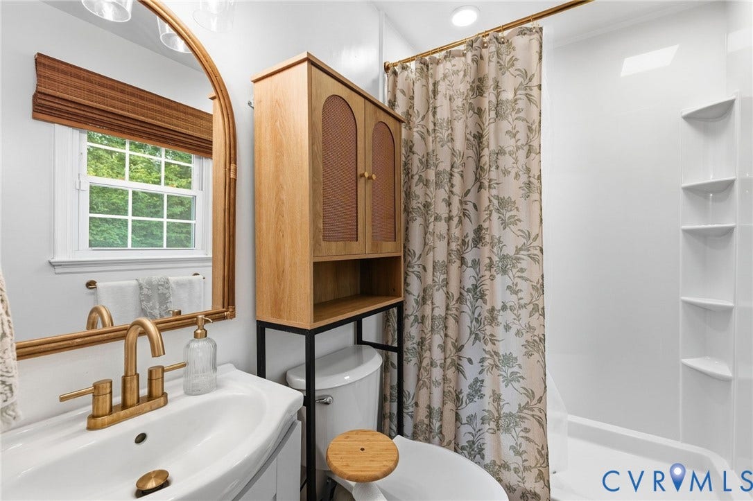 6723 Cherry Road, Woodhaven Shores, Quinton, VA 23141 Single sink vanity with brass-finish faucet, framed mirror, and window with natural light