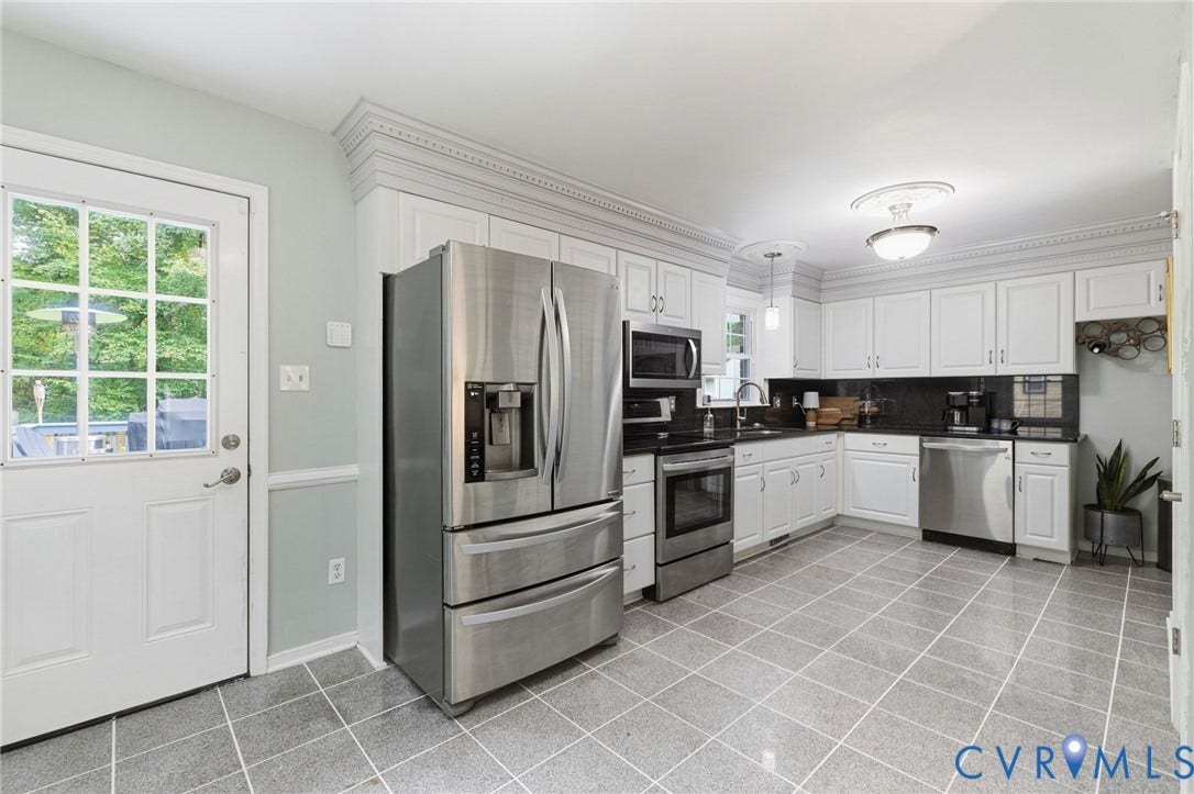 6723 Cherry Road, Woodhaven Shores, Quinton, VA 23141 White cabinetry, black countertops, stainless steel appliances, tiled flooring, and crown molding