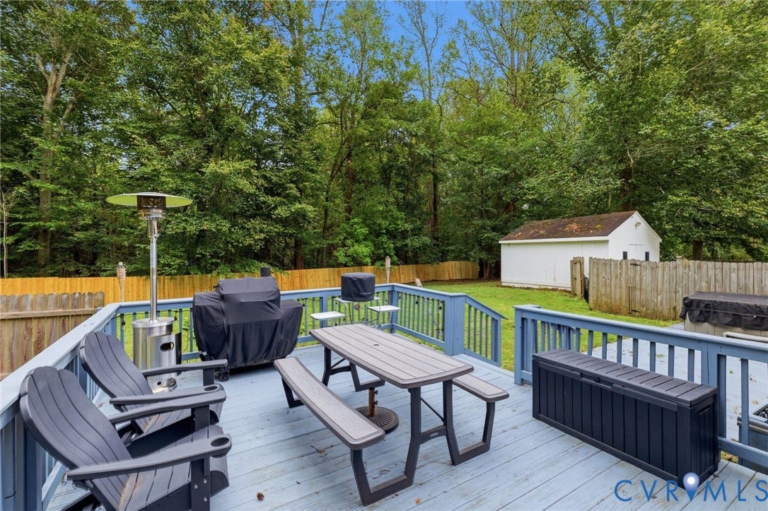 6723 Cherry Road, Woodhaven Shores, Quinton, VA 23141 Expansive wood deck with blue railings, a large backyard, and a white storage shed