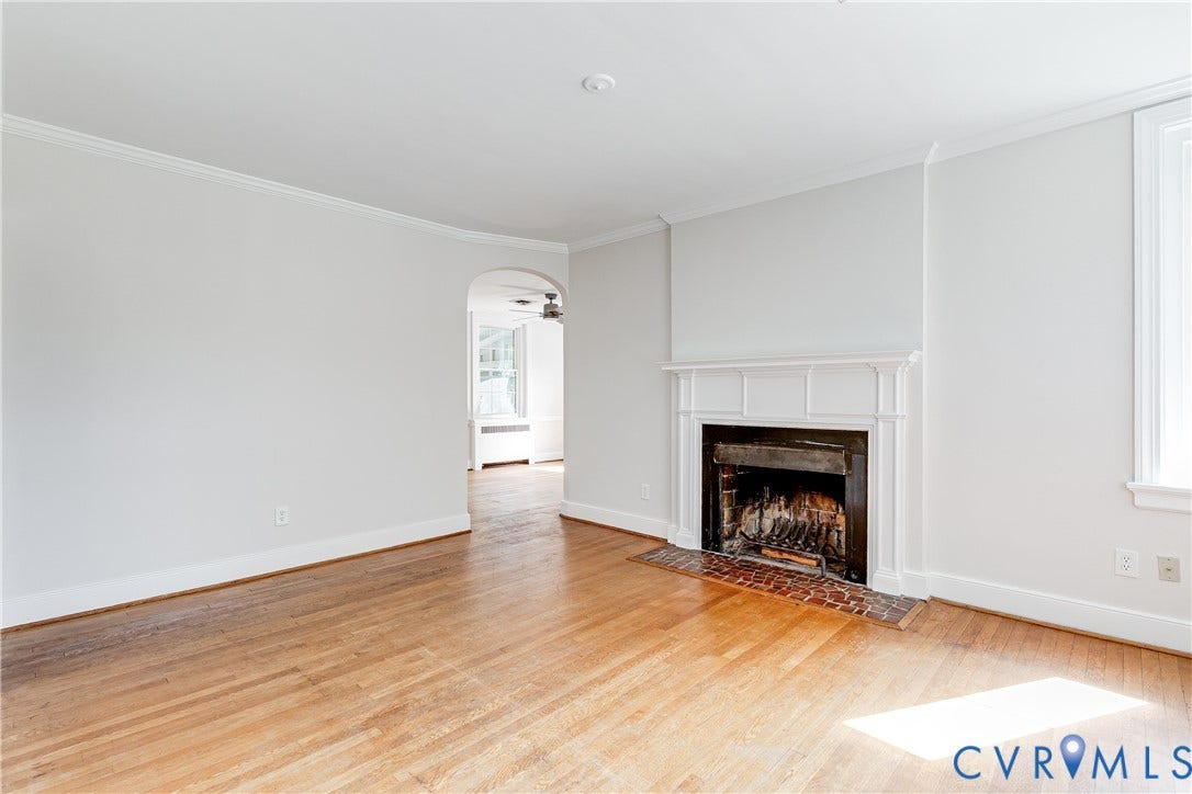 4010 Patterson Avenue, #2ndfl, Richmond, VA 23221 Hardwood flooring throughout, white crown molding, white baseboards, and a white mantel with a dark firebox and brick hearth