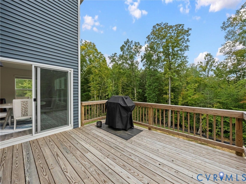 6901 Switch Cane Court, The Arbors, New Kent, VA 23141 Expansive outdoor deck with wood railing, offering a treed backdrop