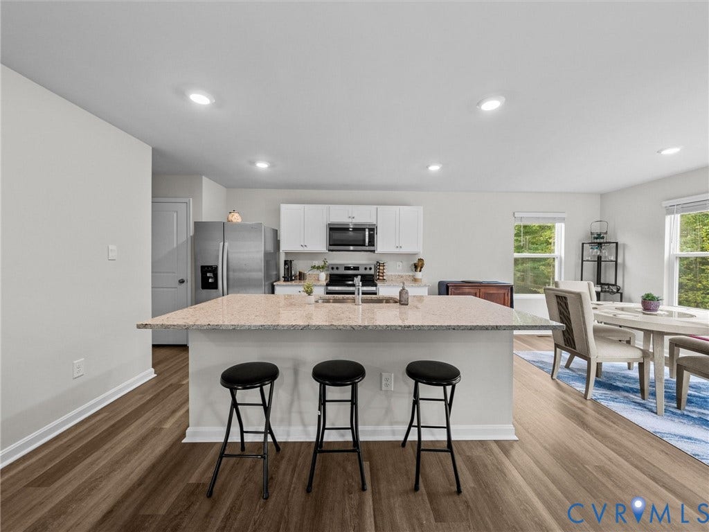 6901 Switch Cane Court, The Arbors, New Kent, VA 23141 Open-concept kitchen featuring an island with stone countertop, stainless steel appliances, recessed lighting, and wood-finish flooring