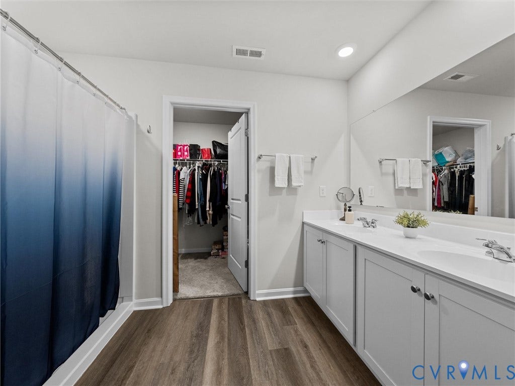 6901 Switch Cane Court, The Arbors, New Kent, VA 23141 Dual vanity with integrated sinks, wood-finish flooring, recessed lighting, and a full-width mirror