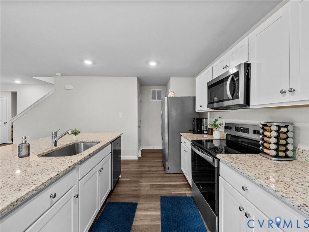 6901 Switch Cane Court, The Arbors, New Kent, VA 23141 Kitchen featuring white cabinetry, light-toned countertops, stainless steel appliances, and wood-finish flooring