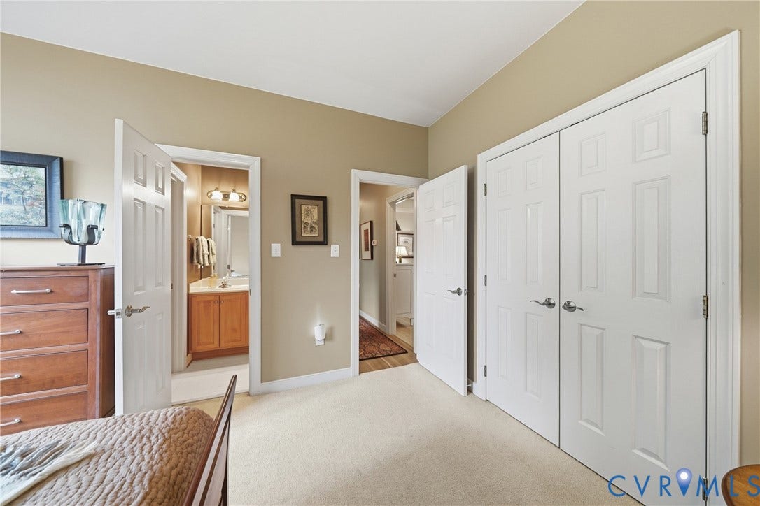 Carpeted flooring, neutral wall tones, multiple panel doors, and architectural trim