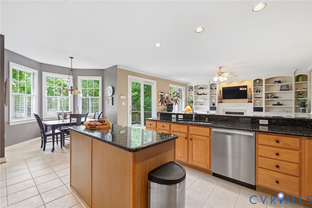 Kitchen featuring a central island, granite countertops, wood cabinetry, and stainless steel appliances