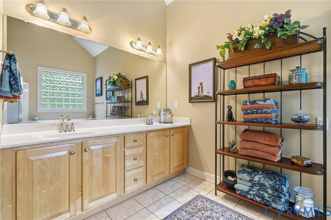 Dual vanity with light wood cabinetry and white countertops