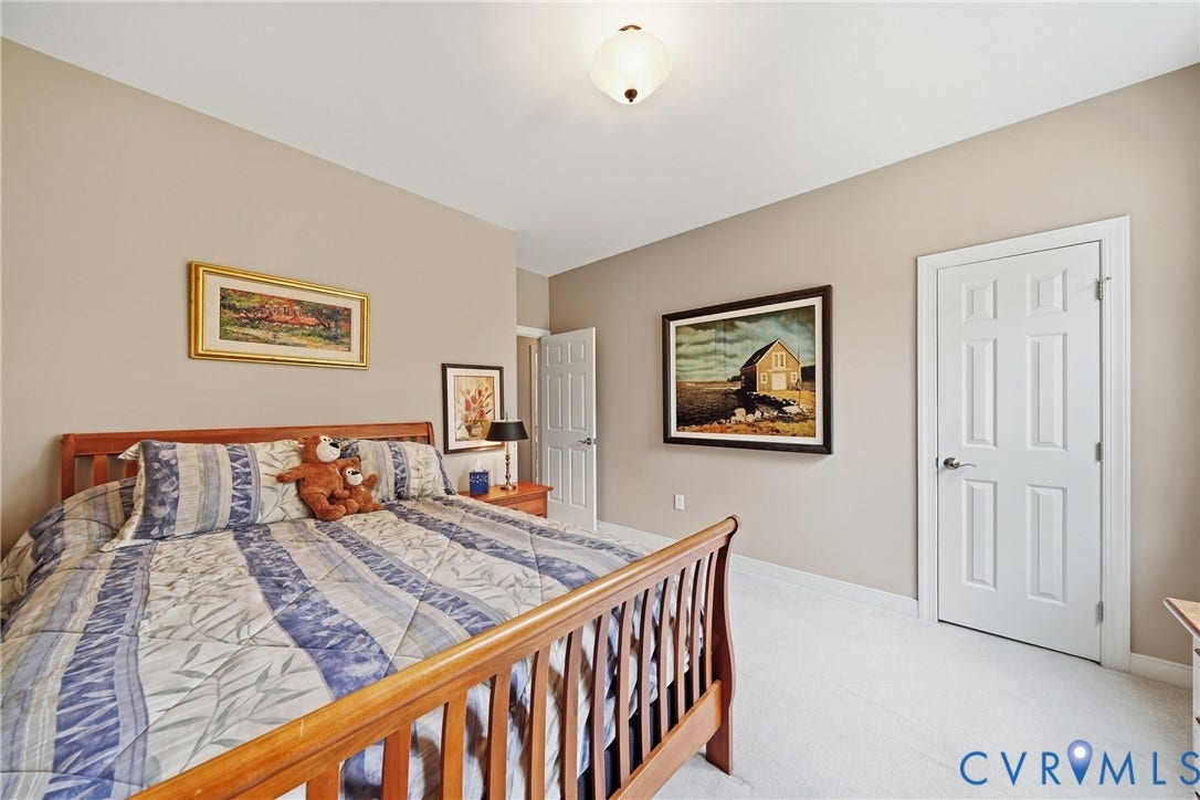 Recessed lighting and a flush mount fixture illuminate the bedroom
