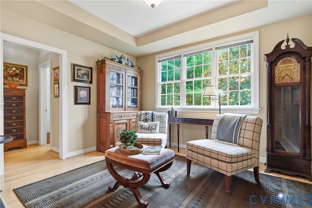 Recessed ceiling, light wood-finish flooring, and a large window with white trim