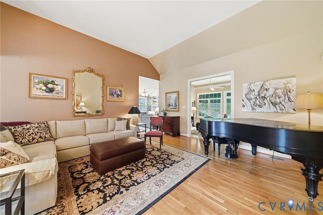 Vaulted ceiling, natural wood-finish flooring, and a wide cased opening