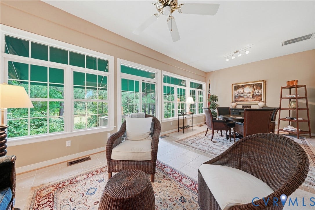 Wall-to-wall windows, tile flooring, and a ceiling fan
