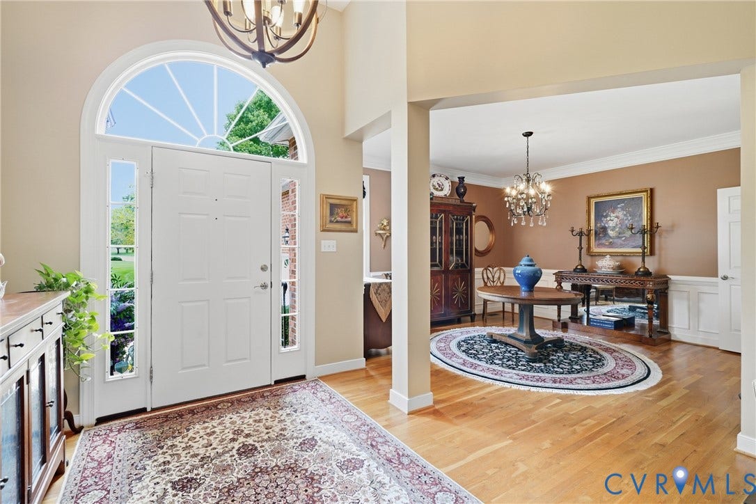 Entry foyer featuring a transom window, side light windows, and wood-finish flooring