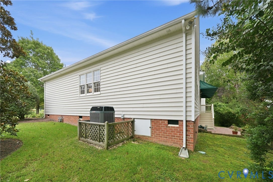 White vinyl siding exterior with a brick foundation and a partial walk-out basement