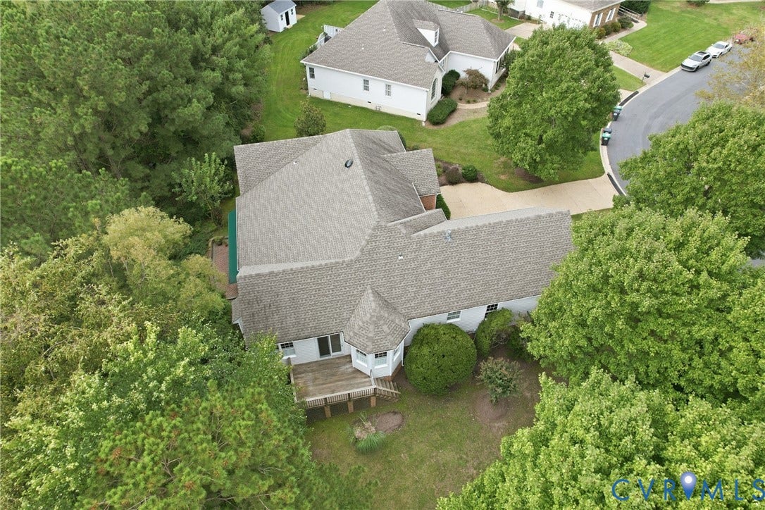Expansive property featuring a multi-gabled roofline, a rear wooden deck, and a circular turretted section