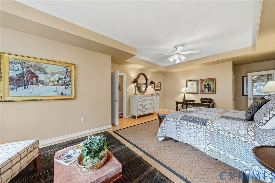 Recessed ceiling with an integrated ceiling fan, light-toned walls, and wood-finish flooring