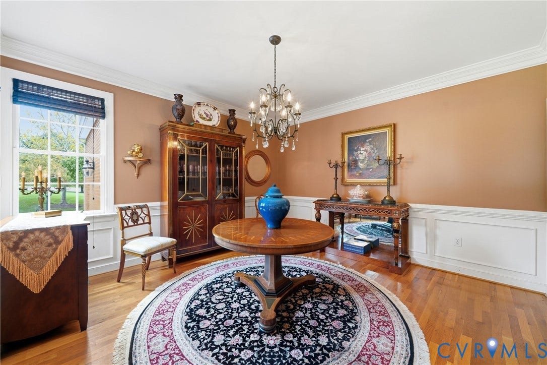 Hardwood flooring, crown molding, chair rail molding, large window, and crystal chandelier