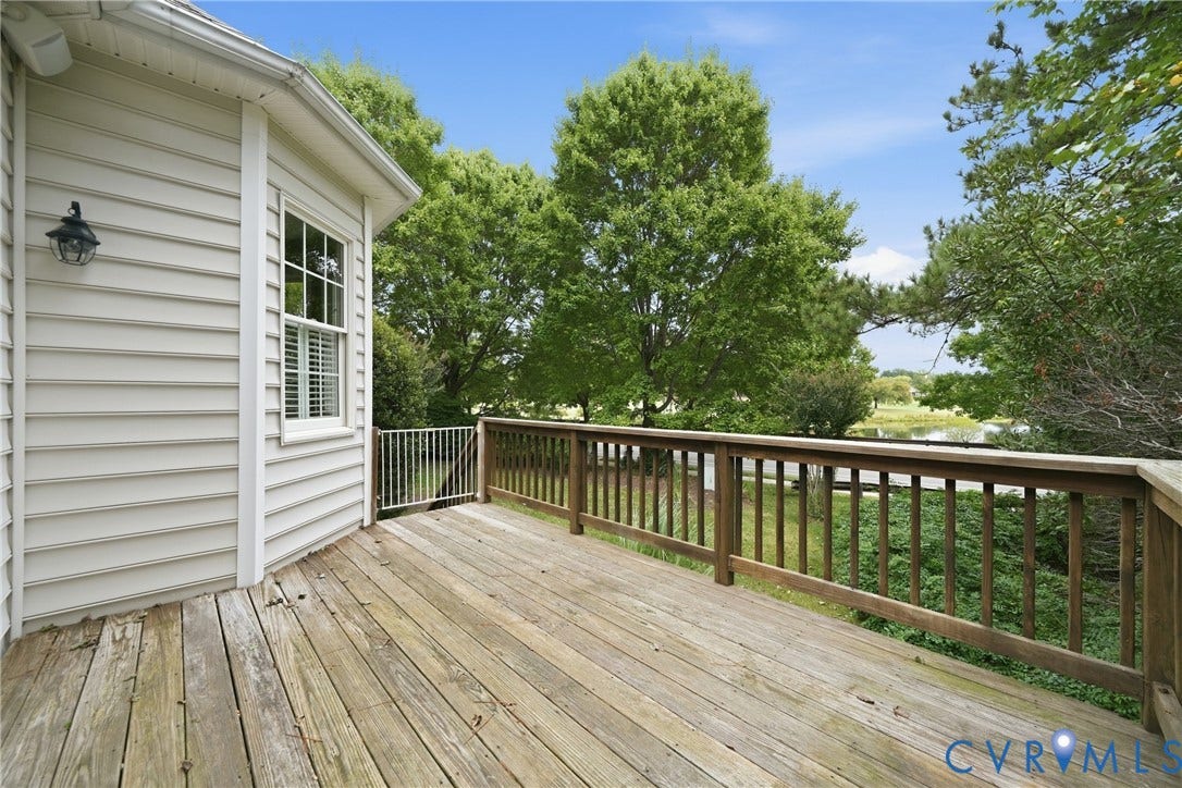 Expansive wood deck with a wood railing, offering broad outdoor living space
