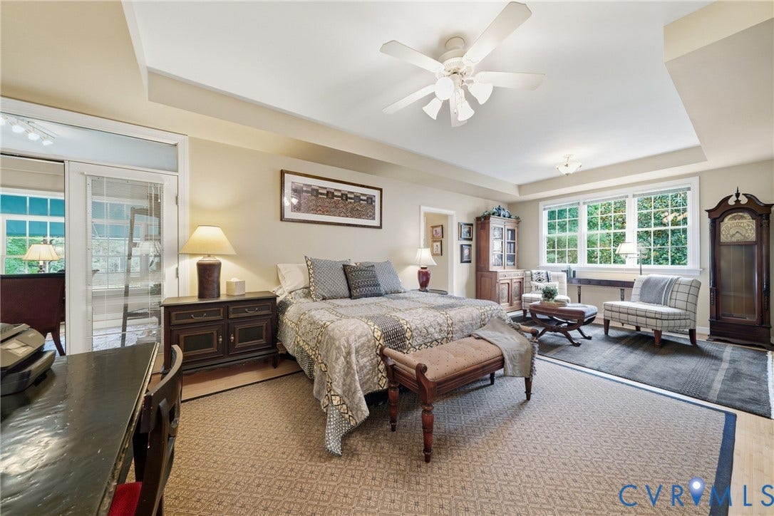 Tray ceiling with a ceiling fan, recessed lighting, and expansive windows