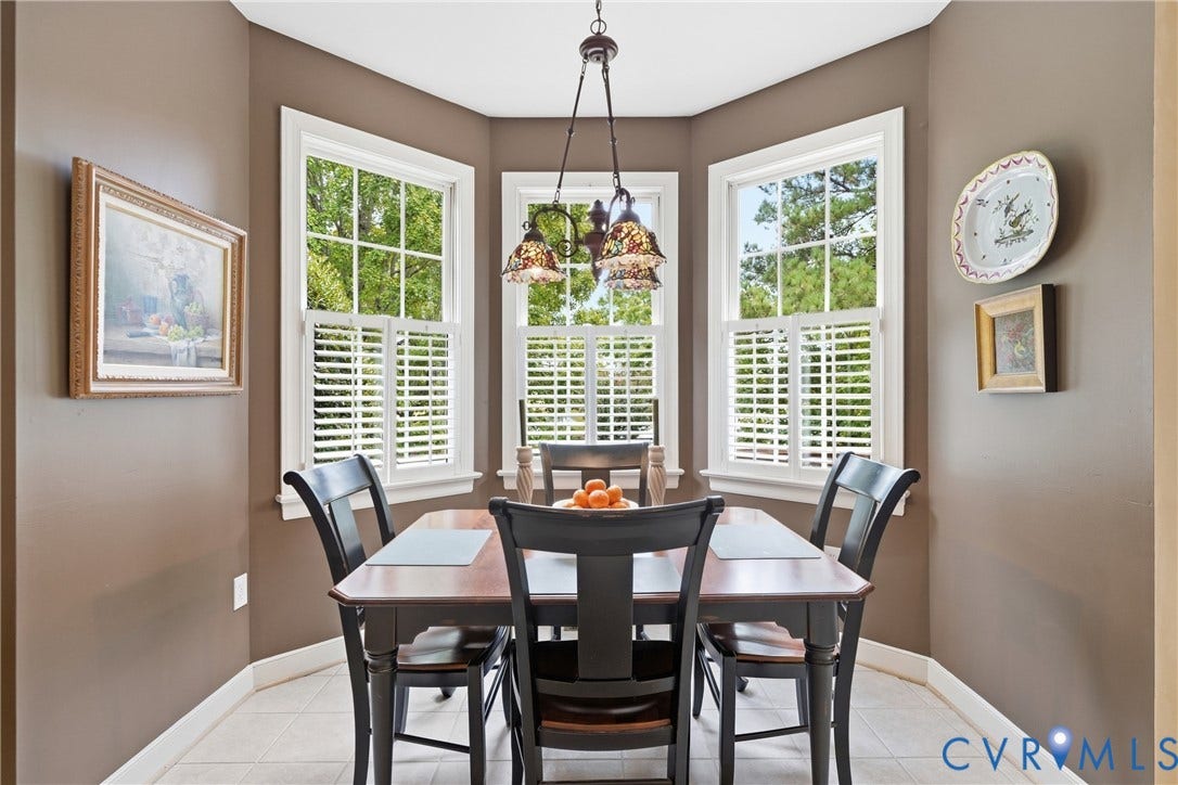 Bay window with three individual windows, white plantation shutters, and a central pendant light fixture