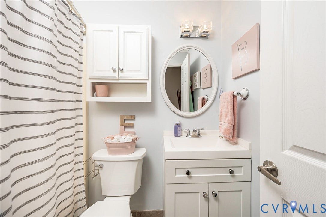 Vanity with an integrated sink, polished chrome faucet, and cabinet storage