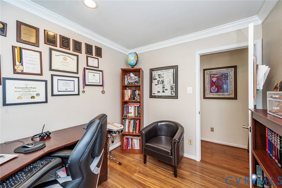 Wood-finish flooring, recessed lighting, crown molding, built-in shelving, and a built-in desk