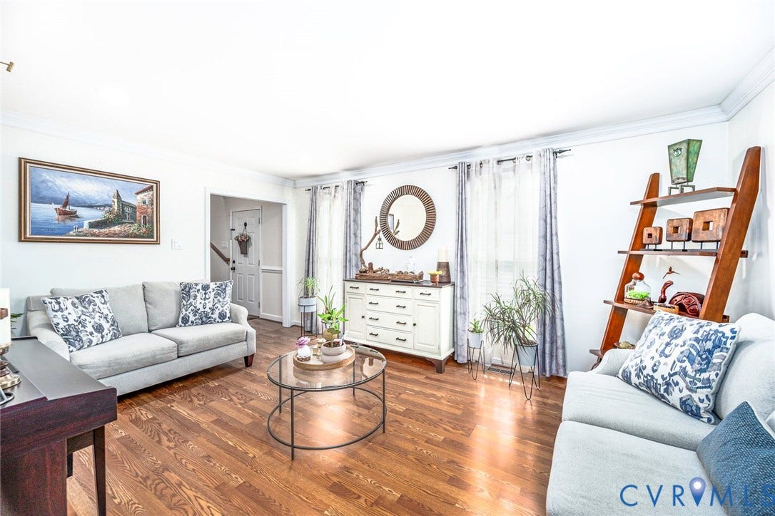 Hardwood-finish flooring, white painted walls, crown molding, and a built-in shelving unit