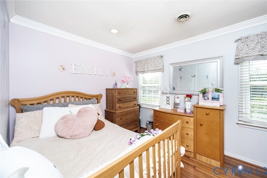 Crown molding and recessed lighting complement the wood-finish flooring