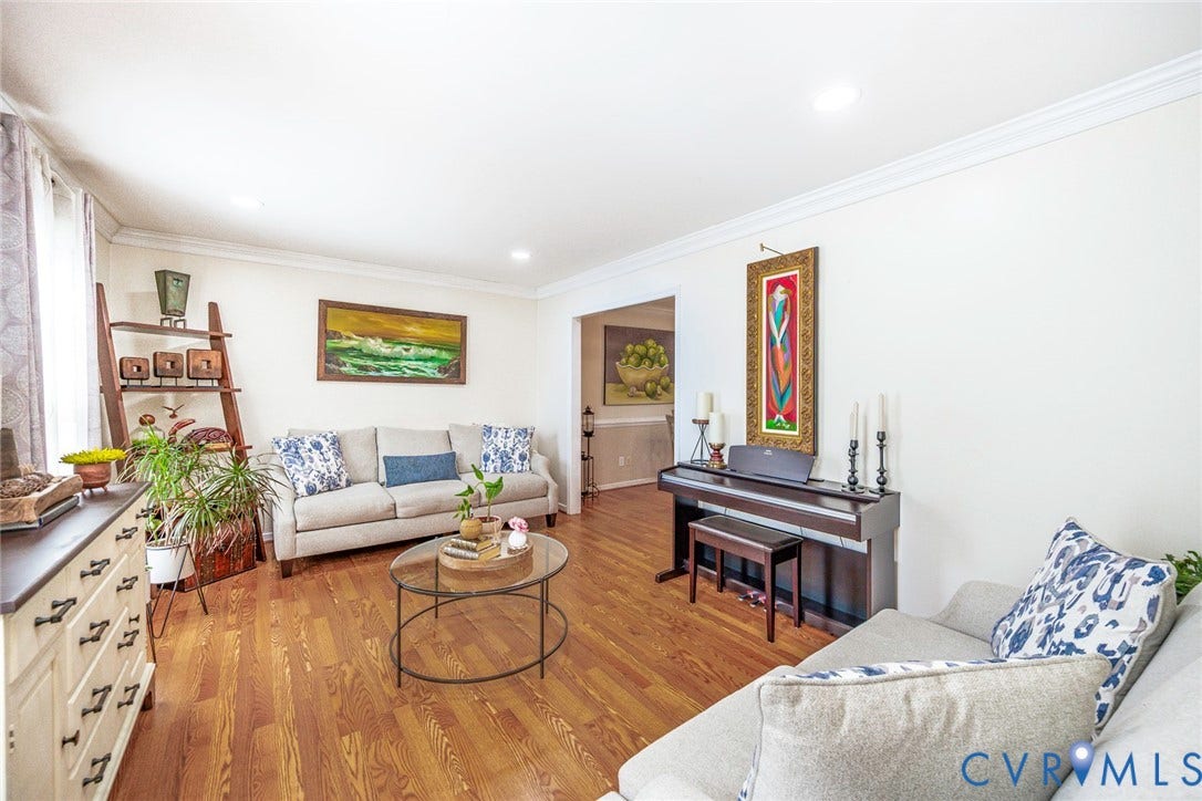 Wood-finish flooring throughout, recessed ceiling lighting, crown molding, and an arched entryway