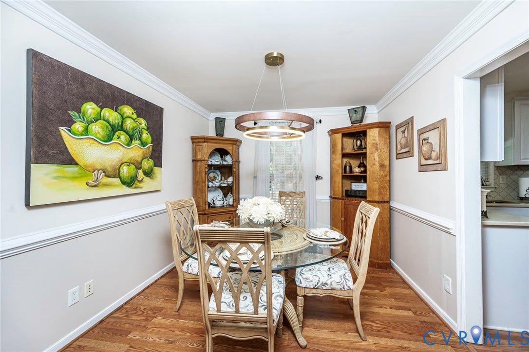 Crown molding, chair rail molding, wood-finish flooring, recessed lighting, and a contemporary chandelier