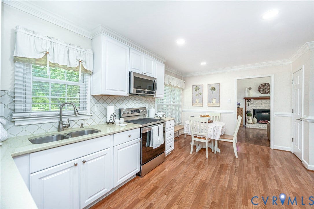 Kitchen with white cabinetry, stainless steel appliances, and a double basin sink