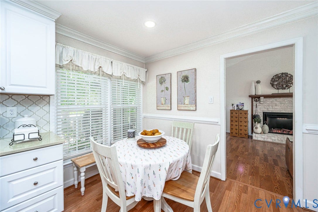 White cabinetry with polished hardware, a patterned tile backsplash, and a granite-finish countertop