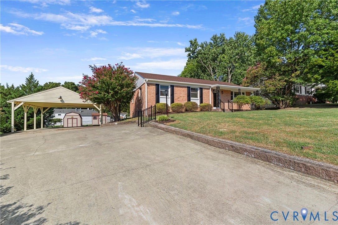7402 Edgewood Avenue, Richmond, VA 23227 Brick exterior, concrete driveway, carport, sloped front lawn, and mature trees