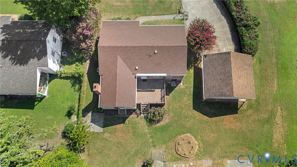 7402 Edgewood Avenue, Richmond, VA 23227 Brown shingle roof with a chimney structure, an outdoor deck with stairs, a detached carport, and a surrounding green lawn