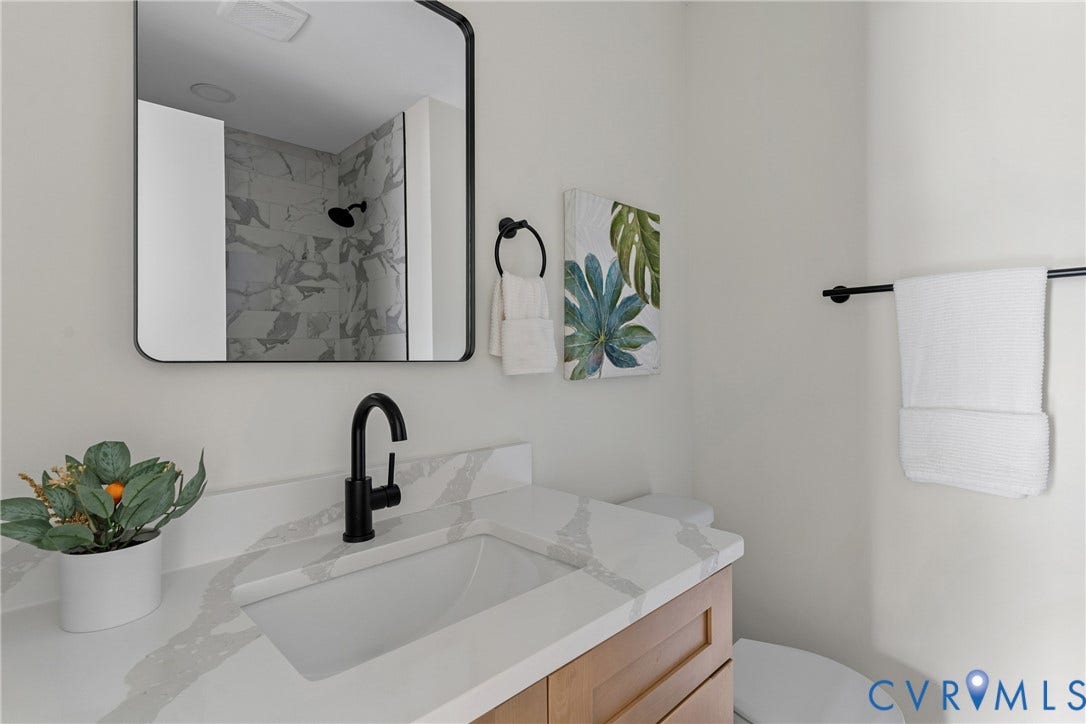 7402 Edgewood Avenue, Richmond, VA 23227 Light wood-finish vanity with an integrated rectangular sink