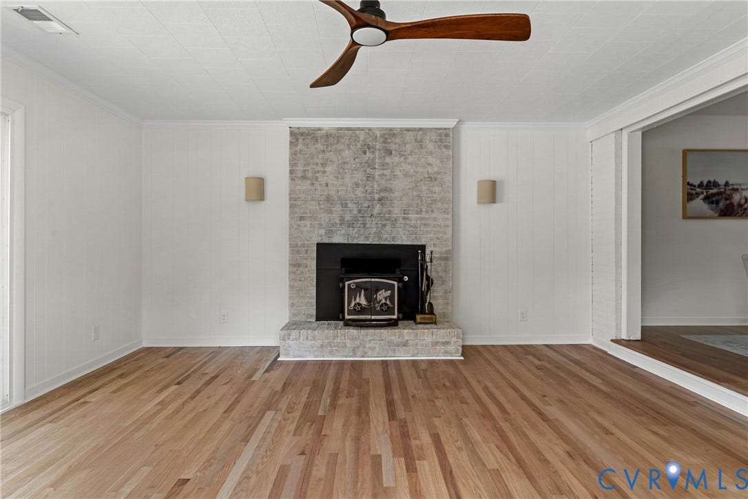 7402 Edgewood Avenue, Richmond, VA 23227 Hardwood flooring throughout, featuring a brick fireplace with a wood-burning insert