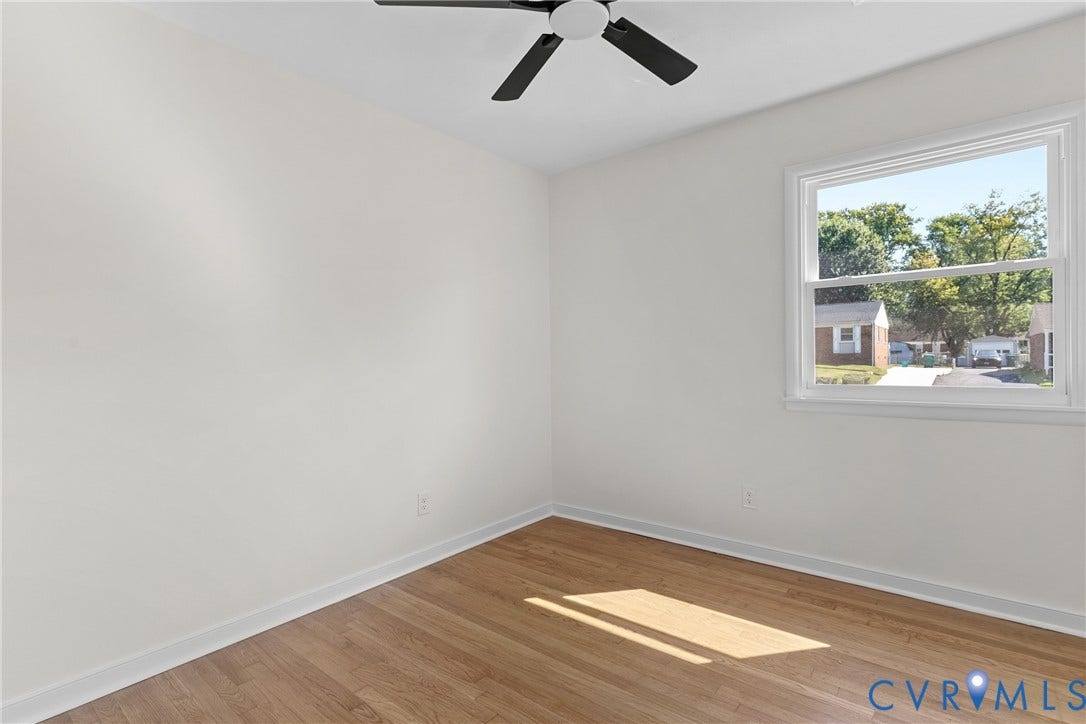 7402 Edgewood Avenue, Richmond, VA 23227 Wood-finish flooring, white walls, white window trim, and a ceiling fan