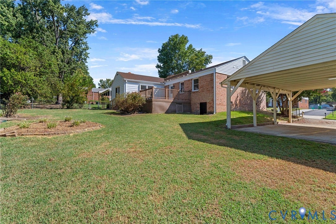 7402 Edgewood Avenue, Richmond, VA 23227 Expansive backyard with a manicured lawn, an elevated wood deck, and a detached carport