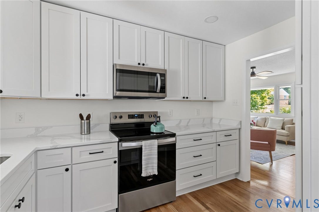 7402 Edgewood Avenue, Richmond, VA 23227 White shaker-style cabinetry, stainless steel appliances, light-toned countertops, wood-finish flooring, and recessed ceiling lighting