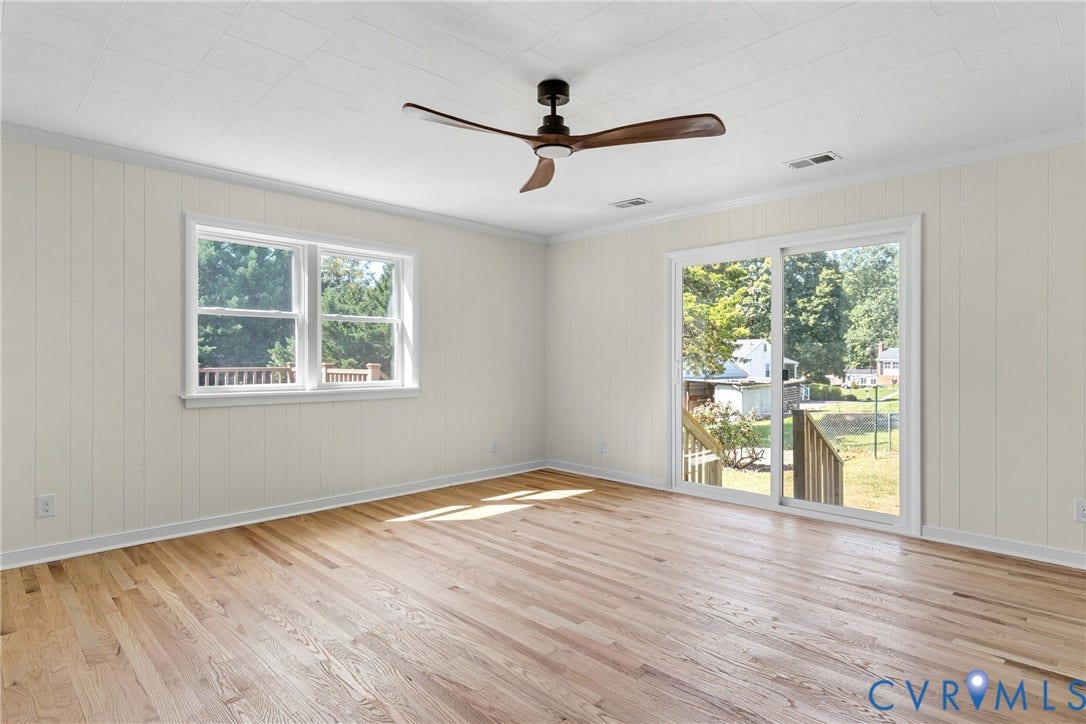 7402 Edgewood Avenue, Richmond, VA 23227 Wood-finish flooring, vertical paneling, ceiling fan, and sliding glass door leading to a wooden deck