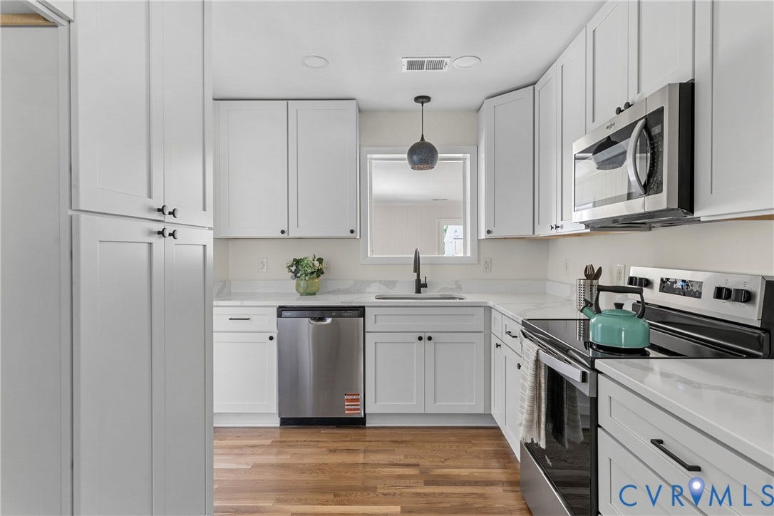 7402 Edgewood Avenue, Richmond, VA 23227 Modern kitchen featuring white shaker cabinetry, stainless steel appliances, white countertops, and wood-finish flooring
