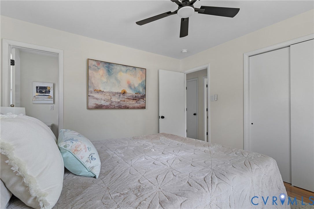 7402 Edgewood Avenue, Richmond, VA 23227 Neutral wall color, ceiling fan with black blades, and white sliding closet doors