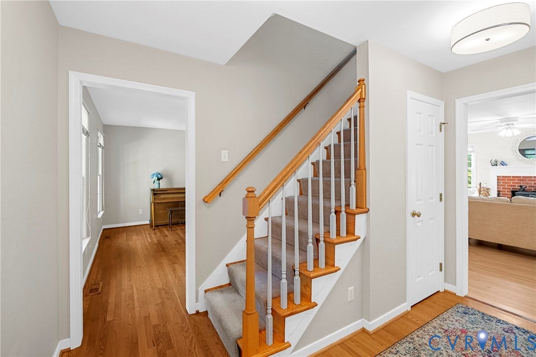 12082 Victoria Hills Road, Rockville, VA 23146 Staircase featuring a natural wood handrail, light-toned balusters, and carpeted treads, complemented by hardwood flooring and a ceiling-mounted drum light fixture