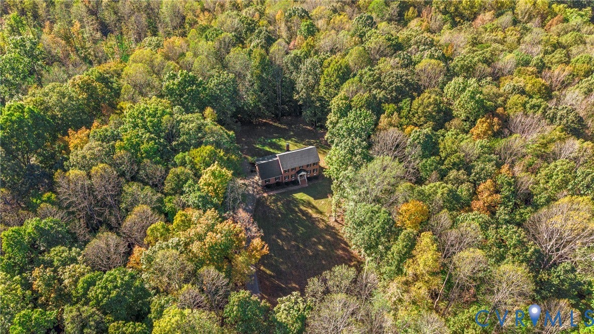 12082 Victoria Hills Road, Rockville, VA 23146 Two-story residential structure featuring a dark-toned shingled roof, set within a lot characterized by extensive mature tree coverage and private woodland