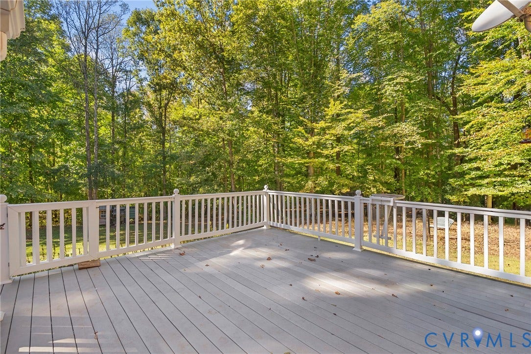 12082 Victoria Hills Road, Rockville, VA 23146 Elevated deck featuring gray composite decking, white picket-style railings, and a wooded backdrop