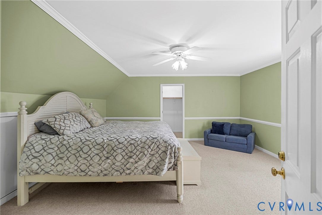 12082 Victoria Hills Road, Rockville, VA 23146 Sloped ceiling featuring crown molding, neutral carpeting, chair rail trim, and a ceiling-mounted light fixture with fan