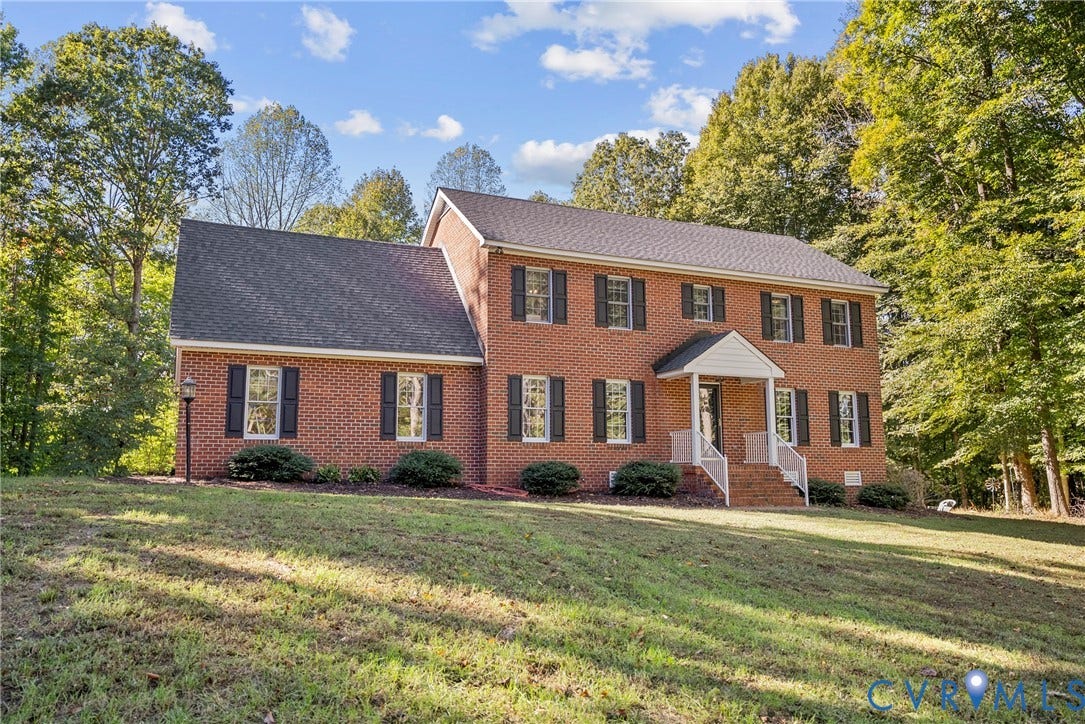 12082 Victoria Hills Road, Rockville, VA 23146 Two-story brick exterior featuring a gable-roofed front entry portico, white railings, and symmetrically placed dark shutters
